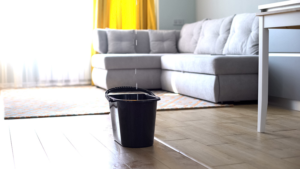 image of a water bucket collecting leaking water from the floor above in a new home